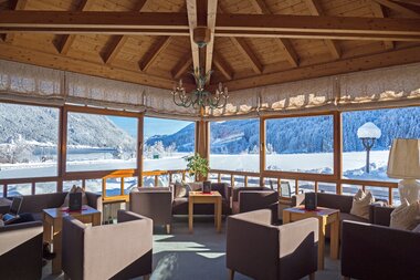 Cozy sunroom with seating and a view of a snowy landscape.